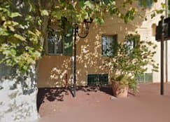 Ruelle calcaire d'un village provençal, ombre d'un platane, façade claire en fin d'après-midi
